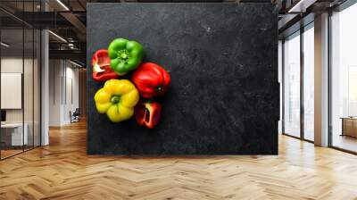 Fresh colored paprika on black stone background. Top view. Free copy space. Wall mural