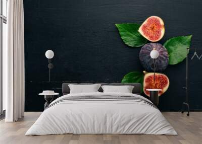 Fresh figs with leaves on a black wooden table. Free space for text. Top view. Wall mural