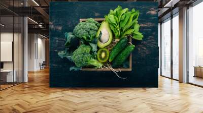 Fresh green vegetables and fruits in a wooden basket. Healthy food. Top view. Copy space. Wall mural