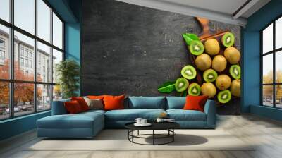 Fresh kiwi and green leaves on the table. Rustic style. Fruits. Top view. Free space for text. Wall mural