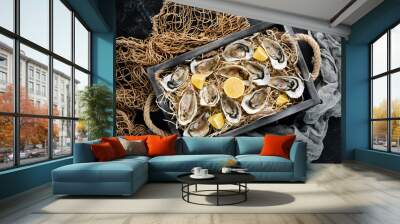 Fresh oysters with lemon in Wooden Box. On a black stone background. Top view. Free copy space. Wall mural