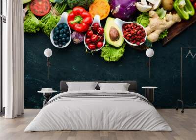 Fresh vegetables and fruits on a black background. Vitamins and minerals. Top view. Free space for your text. Wall mural