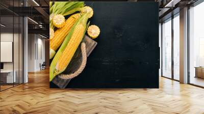 Fresh yellow corn on a black wooden table. Vegetables. Top view. Copy space. Wall mural