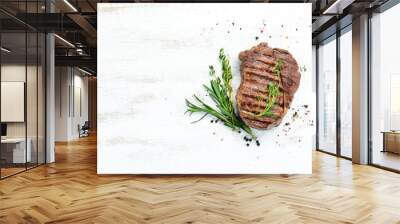 Grilled ribeye beef steak, herbs and spices on a white wooden background. Top view. Free space for your text. Wall mural