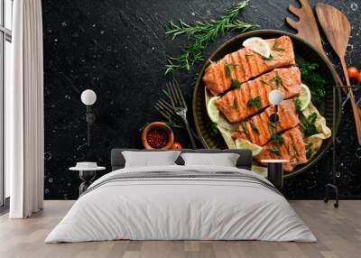 Grilled salmon fillets sprinkled with fresh herbs and lemon juice. On a black background. Wall mural