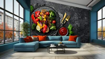 Grilled vegetables (colorful bell pepper, zucchini, eggplant, cherry tomatoes and broccoli) on a black stone plate. Top view. Rustic style. Wall mural