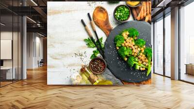 Healthy food: Broiled broccoli, chickpeas and sesame on a black stone plate. Top view. Free space for text. Wall mural