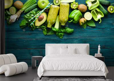 Healthy Green food. Fruits and vegetables - avocado, lime, onion, apple, kiwi, spirulina. On a blue wooden background. Top view. Free space for your text. Wall mural