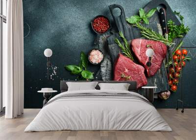 Juicy raw veal with steak spices on a stone background. Veal, meat. Top view. Wall mural