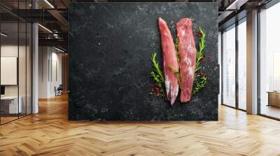 Meat. Raw pork tenderloin with spices on a black stone background. Top view. Rustic style. Wall mural