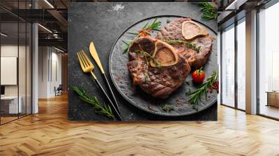 Osso buco cooked Veal shank with spices and rosemary. Barbecue meat. Top view. Flat lay top view on black stone cutting table. Wall mural