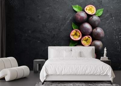 Passion fruits with leaves on a black background. Tropical Fruits. Top view. Free space for text. Wall mural