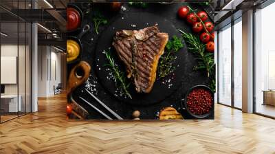 porterhouse steak or T Bone Steak dry aged of beef Ready to Cook on wooden Board with herbs, pepper and salt. On a black stone background. Wall mural