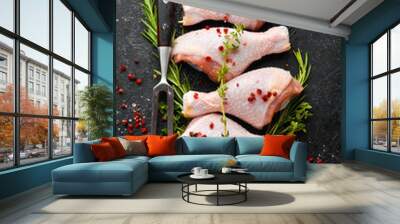 Raw chicken drumsticks with spices on a black stone background. Meat. Top view. Rustic style. Wall mural