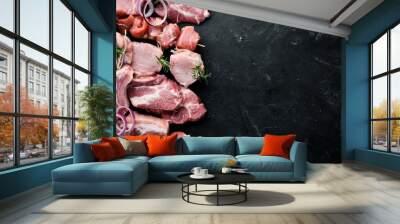 Raw meat for barbecue. Meat with spices and herbs. On a black stone background. Top view. Free copy space. Wall mural