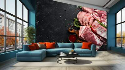 Set of raw meat. Pork meat on black stone background with spices and herbs. Top view. Rustic style. Wall mural