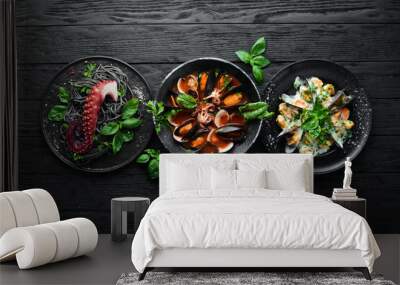 Set of Seafood Dishes. Seafood on a plate. On a black wooden background. Top view. Free copy space. Wall mural