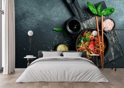 Udon pasta with vegetables and ginger. In a black plate. Japanese cuisine. On a dark background, close-up. Wall mural