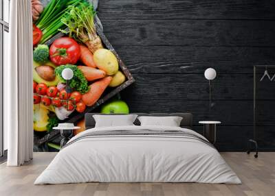 Vegetables in a wooden box. Avocado, cucumber, onion, garlic, tomatoes, carrots, horseradish. Top view. Free space for your text. Wall mural