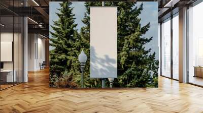 Ultra-tall blank vertical banner on a lamppost, surrounded by mature cedar trees. Wall mural