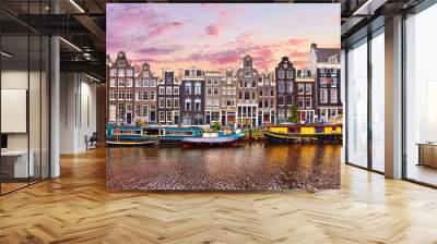 Amsterdam, Netherlands. Floating Houses and houseboats and boats at channels by banks. Traditional dutch dancing houses among trees. Evening autumn street above water pink sunset sky with clouds. Wall mural