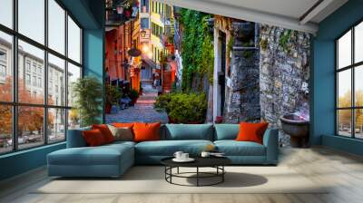 Bellagio, lake Como, Milan, Italy. Famous stone stairs street. Evening Nighttime with blue sky and lights of outdoor lanterns. Picturesque italian architecture of famous luxury Alpine health resort Wall mural