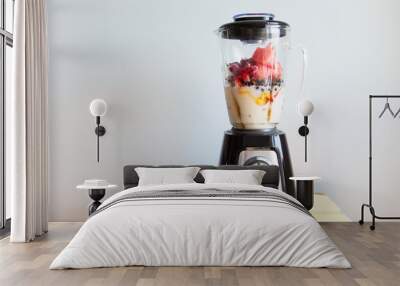 A blender filled with fresh whole fruits for making a smoothie or juice. Healthy eating concept. Wall mural