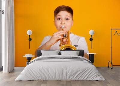 A boy plays the trumpet. Beautiful teenager boy plays trumpet musical instrument Wall mural