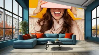 Happy young woman with a gift box in her hands, covers half of h Wall mural