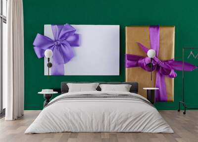 gift card with purple bow and gift wrapping on green background Wall mural