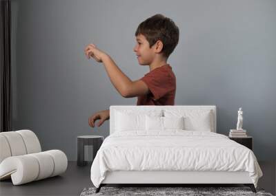 Boy in casual attire impersonates a wild creature, eyes popped and roaring. Reminds viewers of the uninhibited spirit of childhood and the universality of Youngster dramatizes a scare. Wall mural