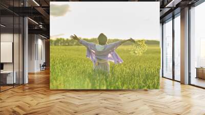 Elderly woman in stylish clothing relaxing in a lush meadow, embodying the fulfilling experiences offered in senior communities Wall mural