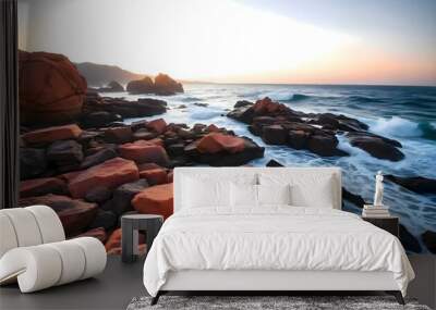 A rocky coastline with crashing waves and vibrant orange and red rocks at sunset, creating a dramatic and serene landscape Wall mural