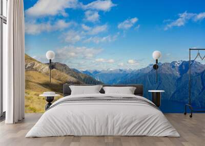 Summit of the Kepler track with a view of a lake in the middle of a mountain range during a sunny day, New Zealand Wall mural