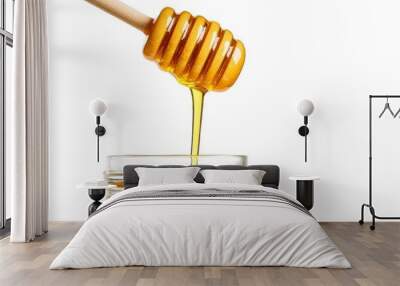 Carefully drizzling honey from a traditional wooden stick dipper into glass jar on white background Wall mural