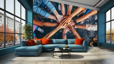 Diverse group of people joining hands together in a circle showing teamwork and unity Wall mural