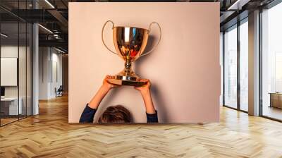 Golden winners trophy cup in the hands of boy copy space isolated  Wall mural