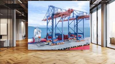 Crane loading box container to cargo ship at commercial dock port. Shipyard Cargo Container Sea Port Freight forwarding service logistics and transportation. International Shipping  Customs Port.. Wall mural