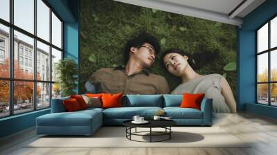 Asian couple sunny day lovers and dreamers in the green grass, photo style shot from above a green field of grass, lovers on a beautiful warm day outside happy togetherness (generative AI, AI) Wall mural