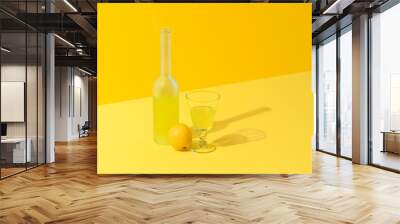 Lemon liqueur bottle and glass on a yellow background. Wall mural