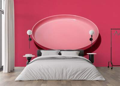 Pink plate isolated on a vibrant magenta background Wall mural