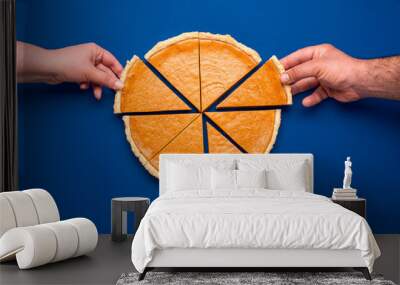 Sliced pumpkin pie above view on blue background. People grabbing slices of cake Wall mural