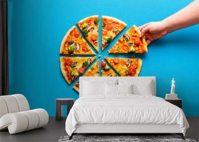 Vegetarian pizza isolated on blue background. Sliced pizza. Grabbing a slice of pizza Wall mural