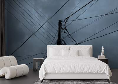 Power supply pole and cables, with dark cloudy sky background Wall mural