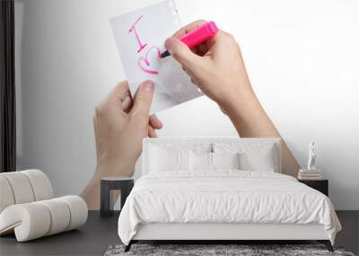 Hands writing a love note using a pink marker, isolated on white background Wall mural