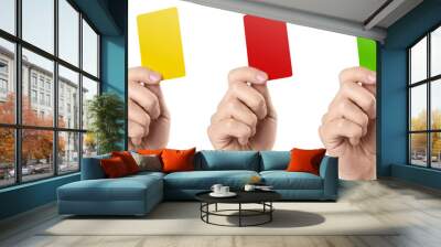 Male football (soccer) referee hand holding yellow, red and green cards, isolated on white background Wall mural