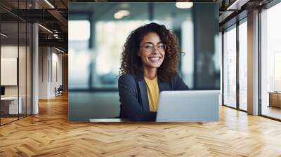 Professional female employee or a businesswoman using a laptop in a modern office. Copy space Wall mural