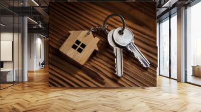 Two house keys with house shaped keychain on wooden background Wall mural