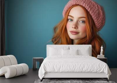 A cheerful young redhead in a green sweater and pink beret, smiling warmly Wall mural