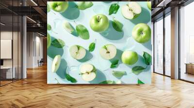 Fresh green apples with leaves on blue background, whole, half, quarter fruits for summer design Wall mural